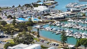 Un puerto deportivo con numerosas embarcaciones amarradas, rodeado de modernos edificios residenciales con paneles solares.