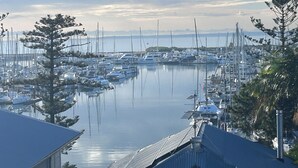 Un puerto deportivo con numerosas embarcaciones amarradas, rodeado de árboles y edificios.