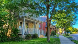 A row of two-story houses with front porches and a sidewalk. - Beautiful 3 bedroom century home steps from uptown (Waterloo)