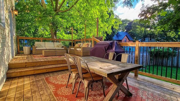 A wooden deck with a table and chairs, a sofa, and a barbecue grill. - Beautiful 3 bedroom century home steps from uptown (Waterloo)
