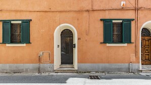 A building with a number 21, two windows with green shutters, and a door with an arched entrance. - GuestHost - Cozy apartment of 70 sqm, able to accommodate up to 4 people, located on the ground floor of a building with private entrance (two steps to access it).The location is enviable, in the center of Pisa, a few steps from Piazza dei Miracoli and t (Pisa)