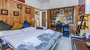 A hotel room with a wooden wall, a bed with white linens, a desk with a computer, and artwork on the walls. - GuestHost - Cozy apartment of 70 sqm, able to accommodate up to 4 people, located on the ground floor of a building with private entrance (two steps to access it).The location is enviable, in the center of Pisa, a few steps from Piazza dei Miracoli and t (Pisa)
