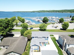 A marina with boats, a parking lot, and residential buildings with a view of the water.