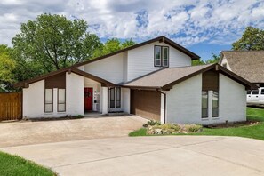 A two-story house with a front garage, a covered entryway, and a small front yard.