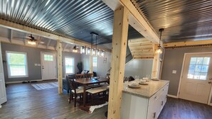 Une cuisine spacieuse dotée d’un îlot central, de meubles en bois et d’une grande fenêtre.