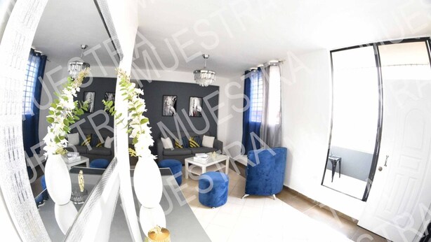 A modern living room with a large mirror, blue sofas, and a chandelier. - Apartamento EN LAS Carreras Centro DE LA Ciudad (Santiago)