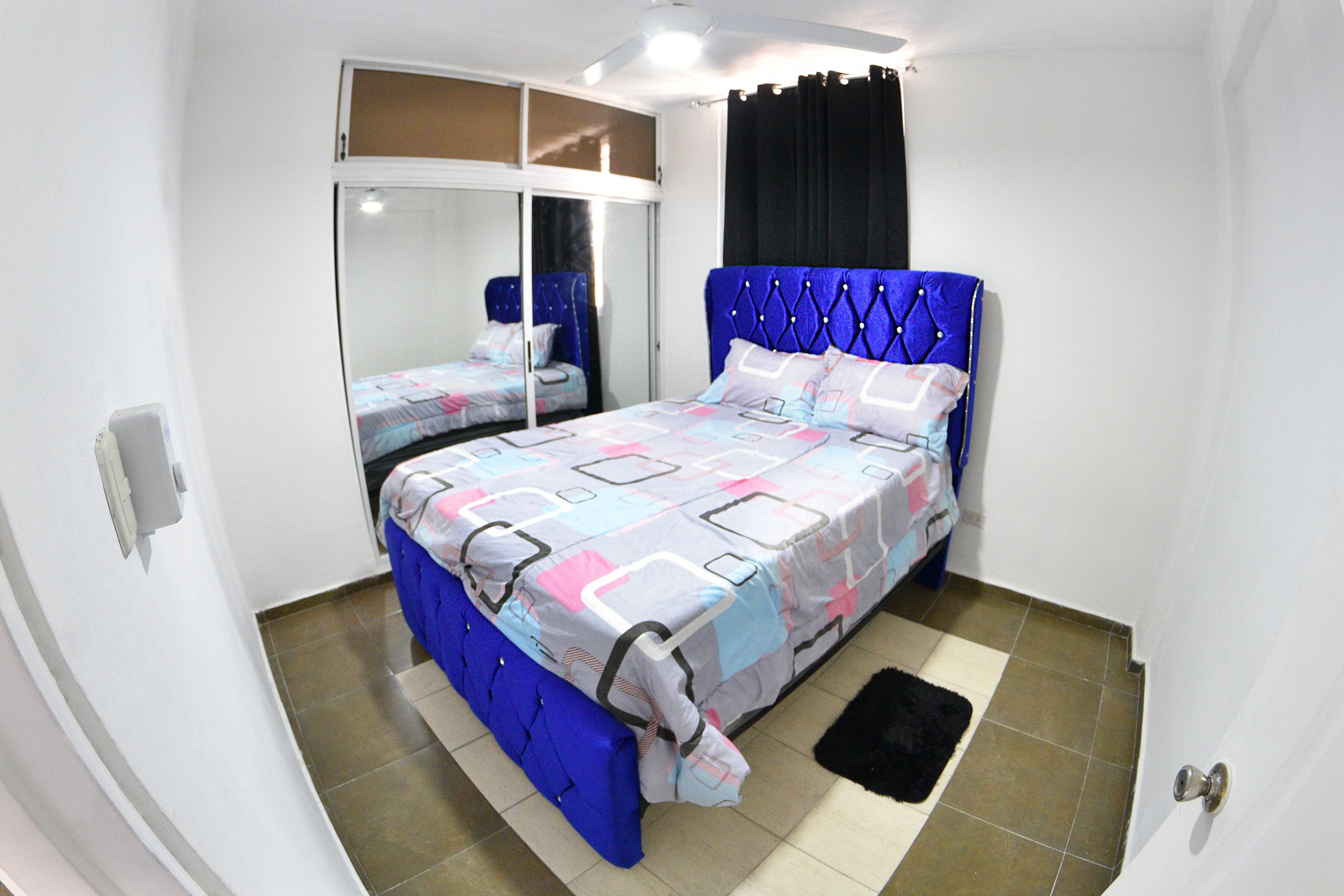Een slaapkamer met een bed, een kledingkast en een spiegel.