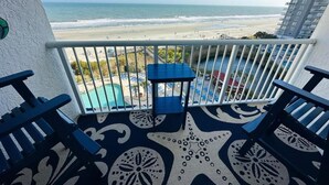 Un balcone con pavimento a motivo di stella marina, una piscina e vista sulla spiaggia e sull'oceano.