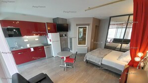 A compact hotel room with a kitchenette, a bed, a small dining table, and a sofa. - Villa "Séduction" (LE CAP D AGDE)
