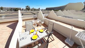 A rooftop terrace with a dining table set for two, equipped with chairs and a table lamp. - Studio 'DEVIL or EDEN" (LE CAP D AGDE)