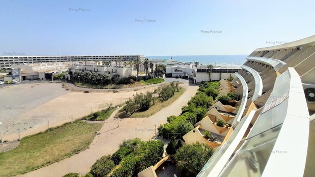 A coastal hotel with a large parking area, a central courtyard with greenery, and a view of the sea. - Studio Ô Plaisir (LE CAP D AGDE)