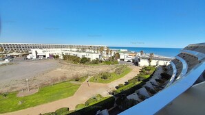 A stadium with a large open field, seating areas, and a view of the ocean. - Studio Ô Plaisir (LE CAP D AGDE)