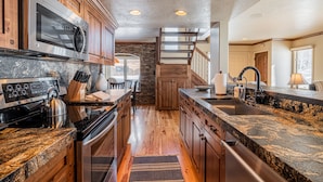 A modern kitchen with granite countertops, stainless steel appliances, and wooden cabinetry. - Beautiful Modern Home in Great Location, Hot Tub +Patio, Luxury Amenities! (Park City)