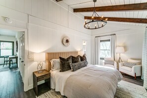 Relax in this serene bedroom with a large bed, two nightstands, and a cozy reading nook.