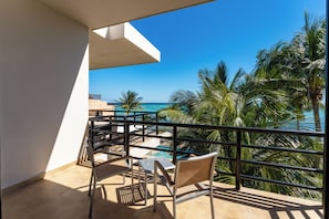 A balcony with a view of the ocean, a pool, and palm trees. - Aparthotel Eeb Ti Kaan Tulum - Luxury Condos. (Tulum)