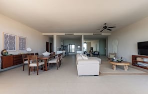 A spacious living area with a dining table, white sofa, and a TV. - Aparthotel Eeb Ti Kaan Tulum - Luxury Condos. (Tulum)