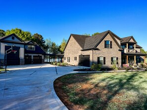A two-story house with a garage, a covered patio, and a well-maintained lawn. - The Lakeside Loft - Covington, GA - Beautiful Lakefront Rental Sleeps up to Four (Covington)