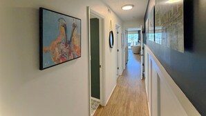 A hallway with a painting, a mirror, and a door leading to a room. - Marshside Inn 201 - Second Row (Marshfront) in Garden City Beach (Garden City)