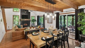 A spacious dining area with a wooden table, chairs, and a fireplace. - 5 Star mountain home where the host thought of everything, so you don’t have to! (Bushkill)