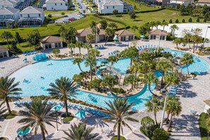 A resort with multiple swimming pools, palm trees, and lounge chairs.