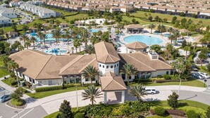 A residential area with multiple houses, a swimming pool, and well-maintained landscaping. - Amazing 3 bedrooms condo in Resort with Water Park (Davenport)