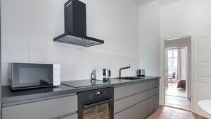A modern kitchen with a built-in microwave, oven, and sink. - Trendy Prenzlauer Berg 1BR, nr Mauerpark, by Blueground (Berlin)