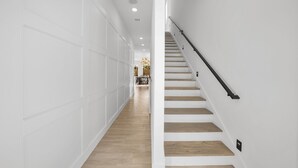 A modern interior with a staircase, white walls, and wooden flooring. - Fall is Near and the Most Wonderful time of year! (Panama City Beach)