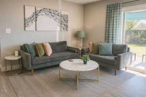 A living room with two sofas, a round coffee table, and a lamp.