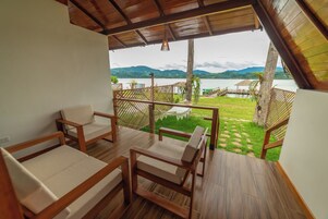 Una terraza de madera con vista a un lago y montañas.