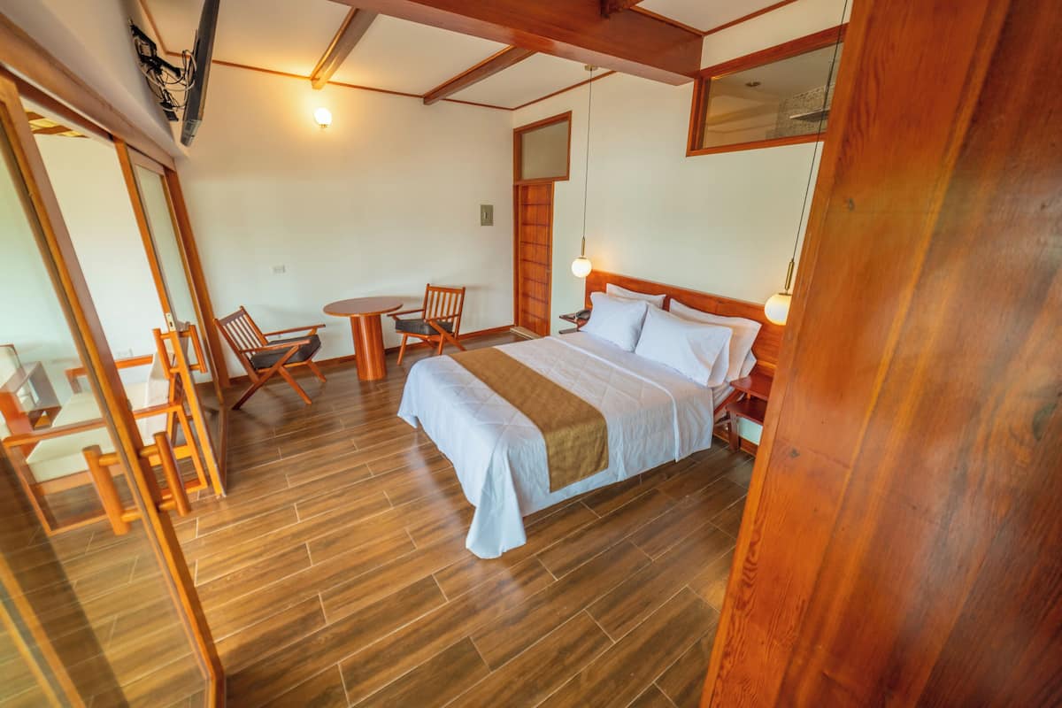 Un dormitorio con cama, mesita de noche y una silla.