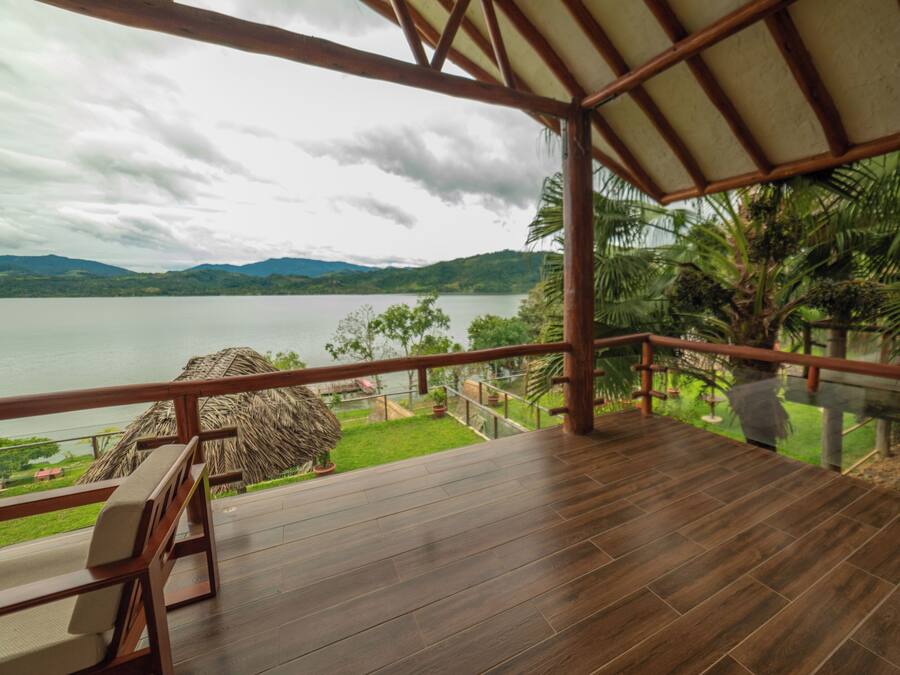 A wooden deck with a view of a lake and mountains.