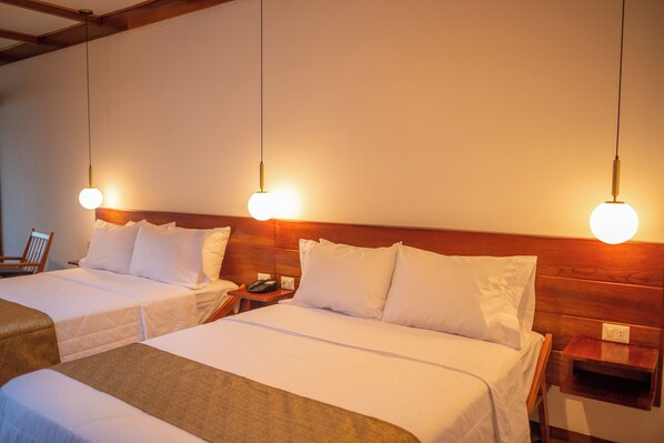 Two single beds with wooden headboards, bedside tables, and a telephone.