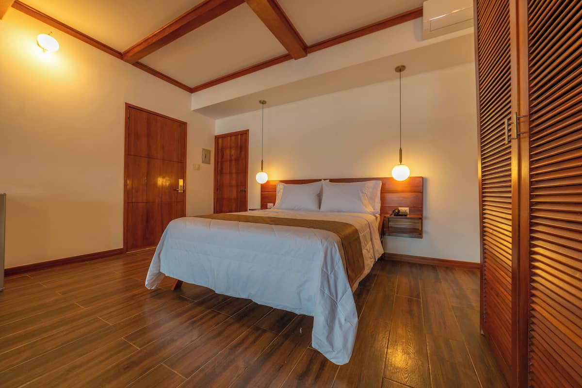 Un dormitorio con una cama de madera, una mesita de noche y una lámpara de pared.