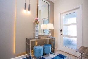 A modern bathroom with a vanity, mirror, and two stools. - 4BR ChampionsGate Private Pool Lazy River Access (Davenport)