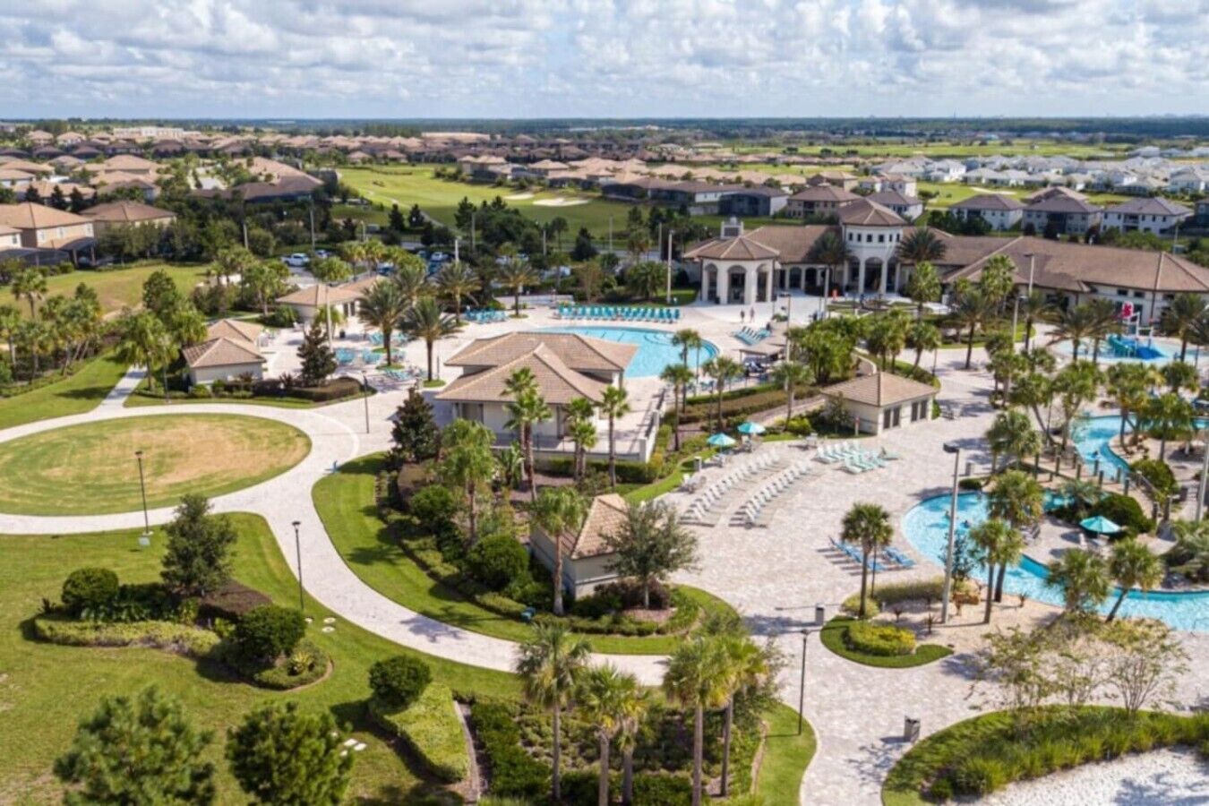 A resort with multiple buildings, a central pool area, and surrounding greenery.