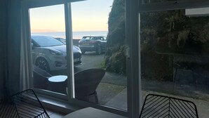Ein Zimmer mit Blick auf geparkte Autos und ein Gewässer.