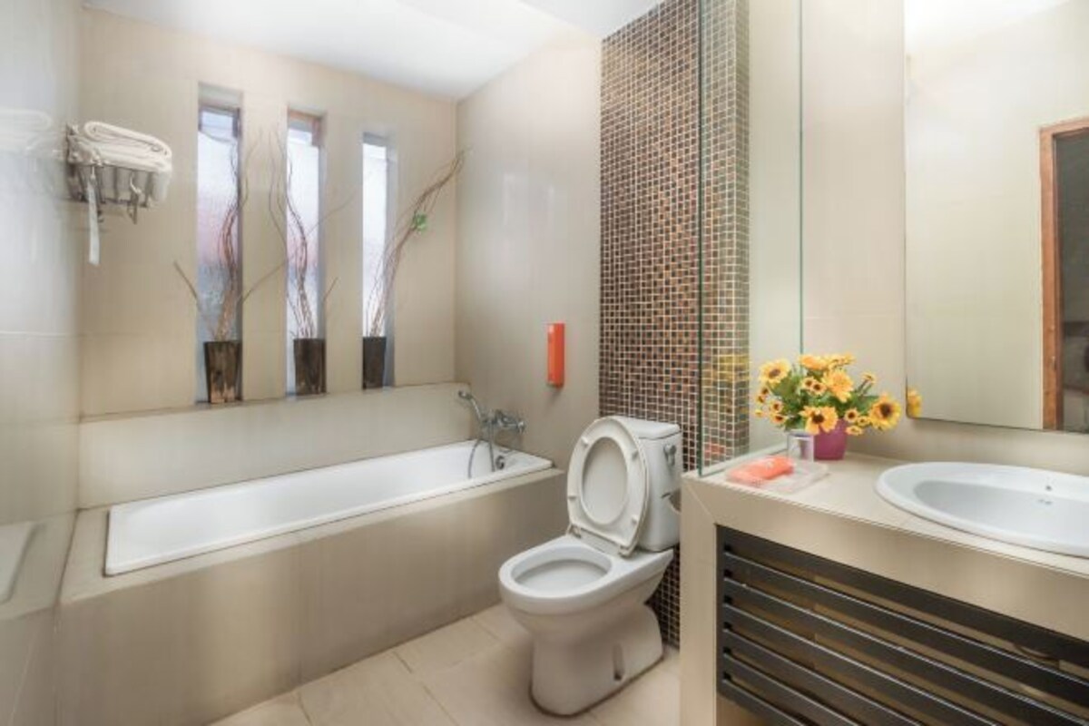 A modern bathroom with a bathtub, toilet, and sink.
