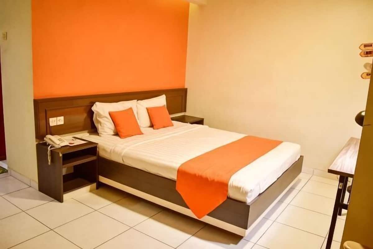 Ein Hotelzimmer mit Bett, Nachttisch und kleinem Tisch.