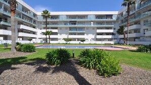 A multi-story hotel with balconies, a swimming pool, and landscaped gardens. - Beautiful vacation apartment in Roses, Costa Brava. Bright, modern, sleeps 4 people. Well-equipped and well-located. (Roses)