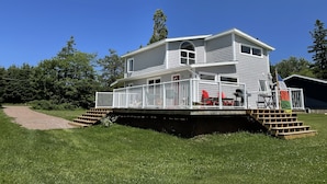 A two-story house with a front deck and a covered porch.