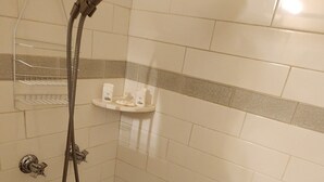 Een douche met een handdouche en een wandmengkraan.
