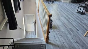 Una escalera con barandilla de madera que conduce a una puerta blanca.