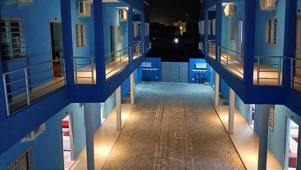 A multi-level building with balconies and railings, featuring a central open space and multiple windows. - Residence MaryHouse (Cotonou)