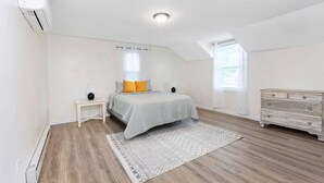 A bedroom with a bed, bedside tables, a dresser, and a window. - *Mins to the Beach | Portsmouth | Maine* (North Hampton)