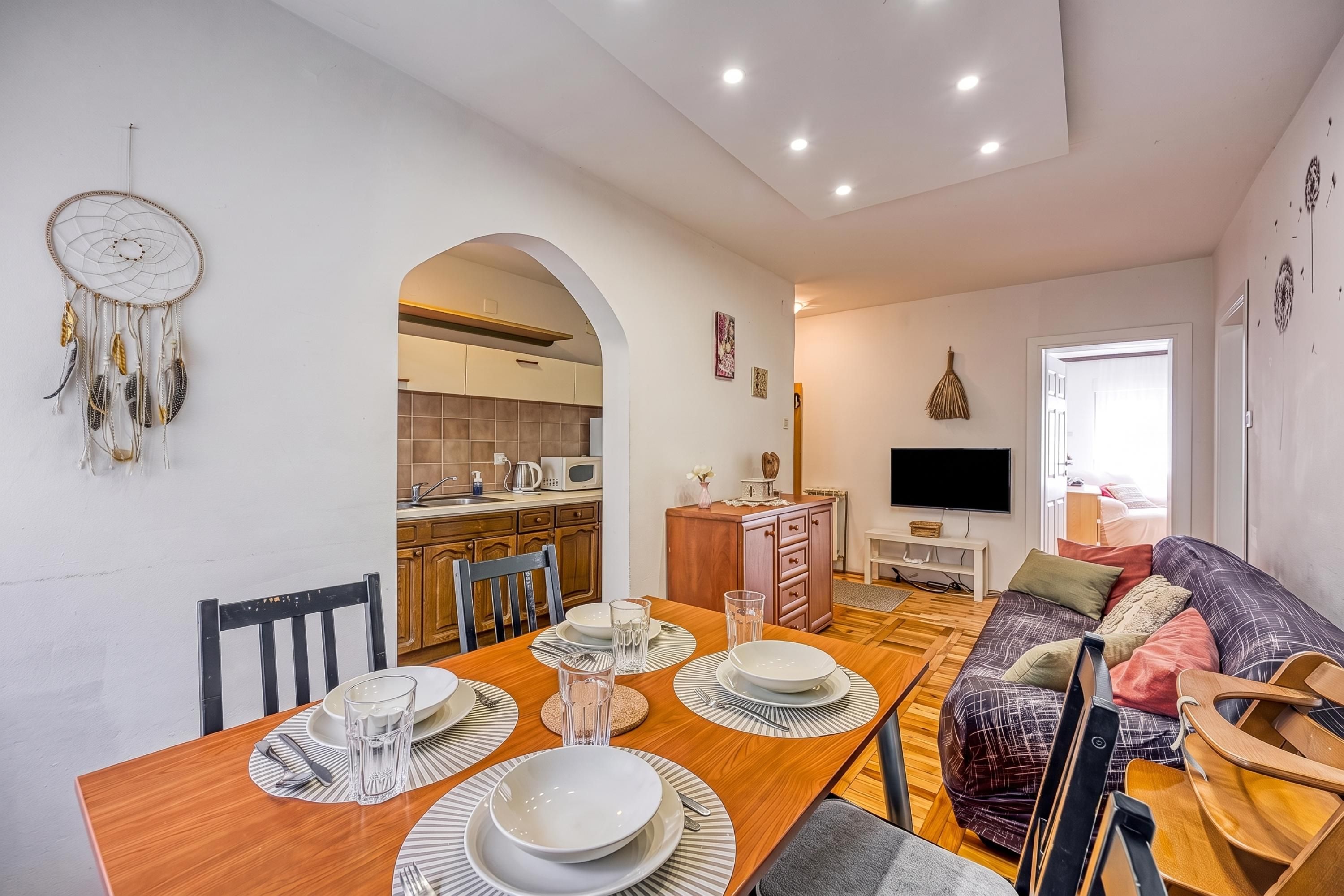 A modern living space with a dining area, kitchen, and a cozy seating area.