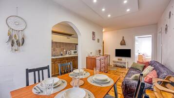 A modern living space with a dining area, kitchen, and a cozy seating area.