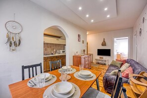 A modern living space with a dining area, kitchen, and a cozy seating area.