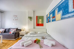 Ein modernes Hotelzimmer mit Bett, einer Sitzecke, einer Wand mit motivierenden Texten und abstrakter Kunst.
