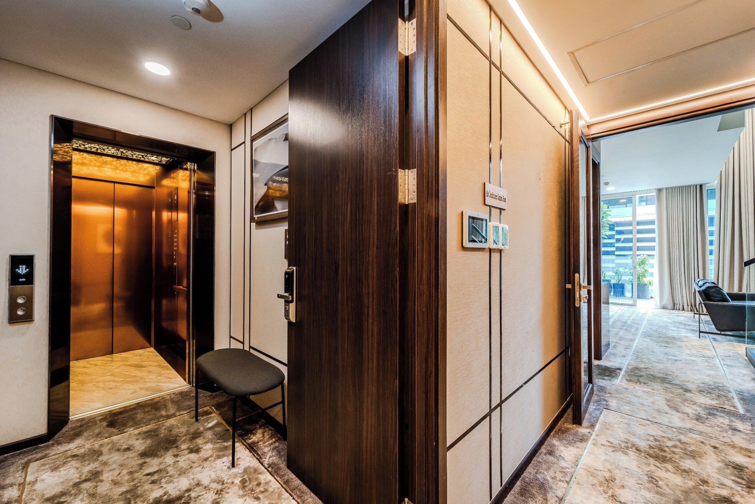 An elevator with a modern design, a wooden door, and a small seating area.