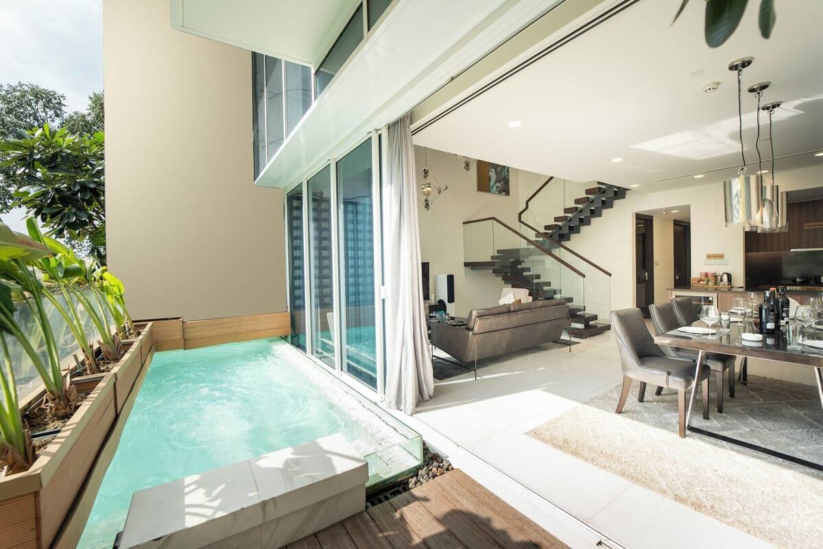 A modern house with a swimming pool, a staircase, and a dining area.